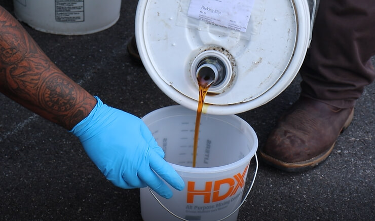 oil being poured in a bucket